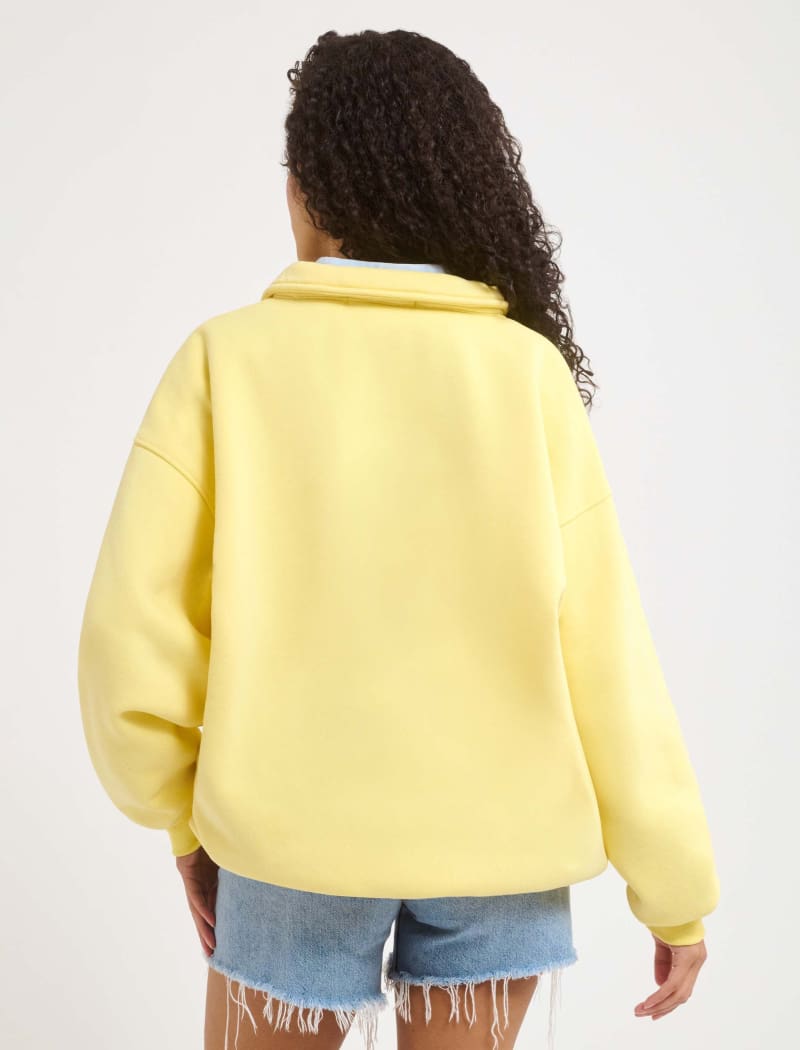 A model poses wearing Rumored 100% Cotton Airport Sweatshirt in Buttercream