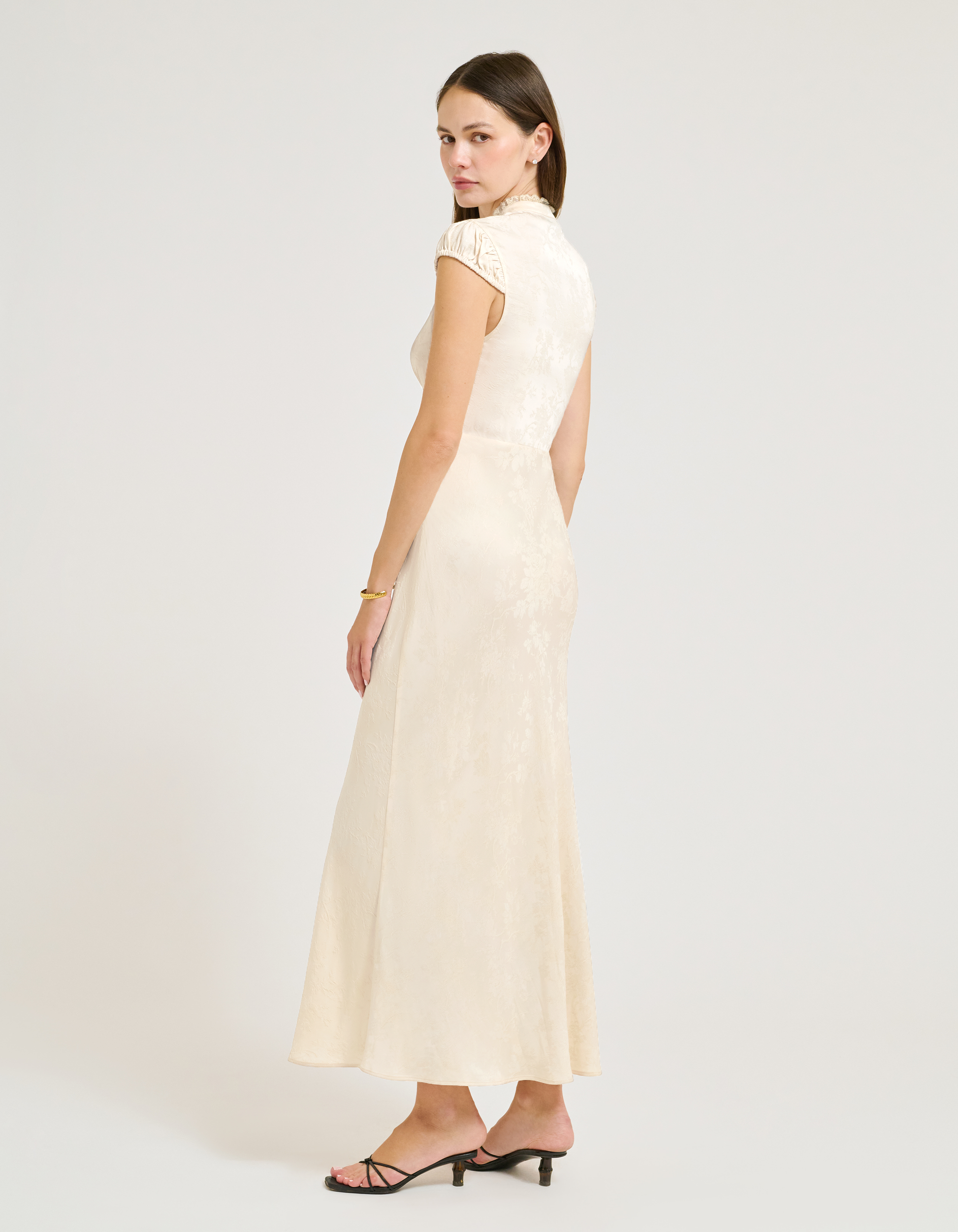 Side view of satin jacquard maxi dress with Lace collar and velvet bow at center.
Cap Sleeves.