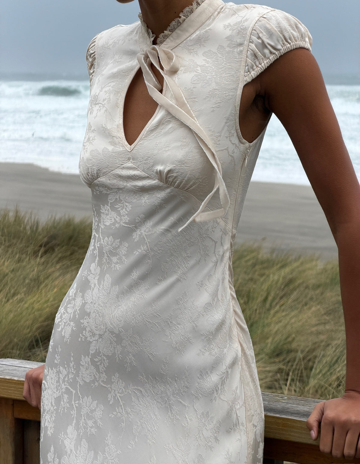 satin jacquard maxi dress with Lace collar and velvet bow at center.
Cap Sleeves.