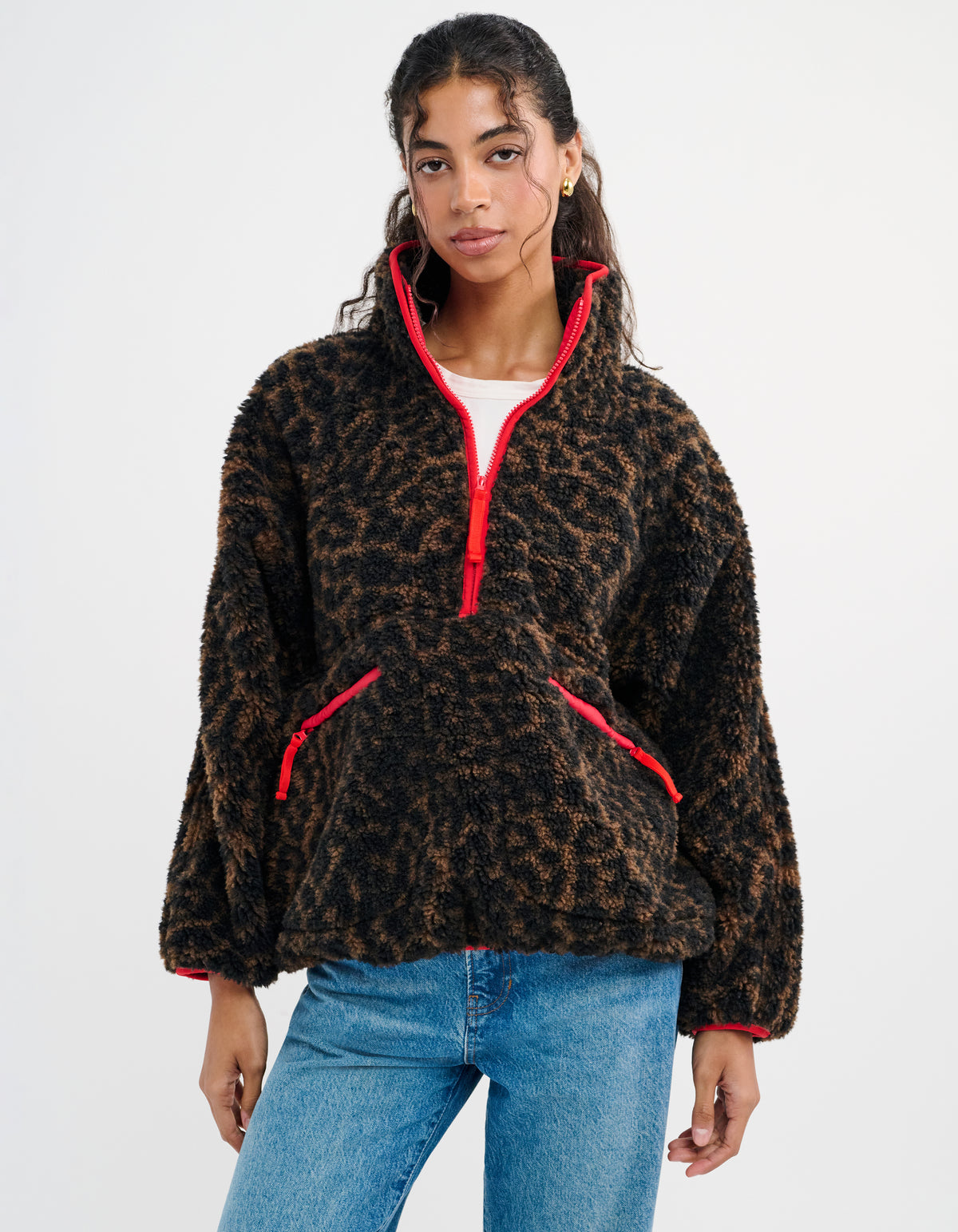 Cheetah Print- featuring a half-zip henley neckline outlined in red, oversized pockets positioned at the waist outlined in red, and raglan sleeves