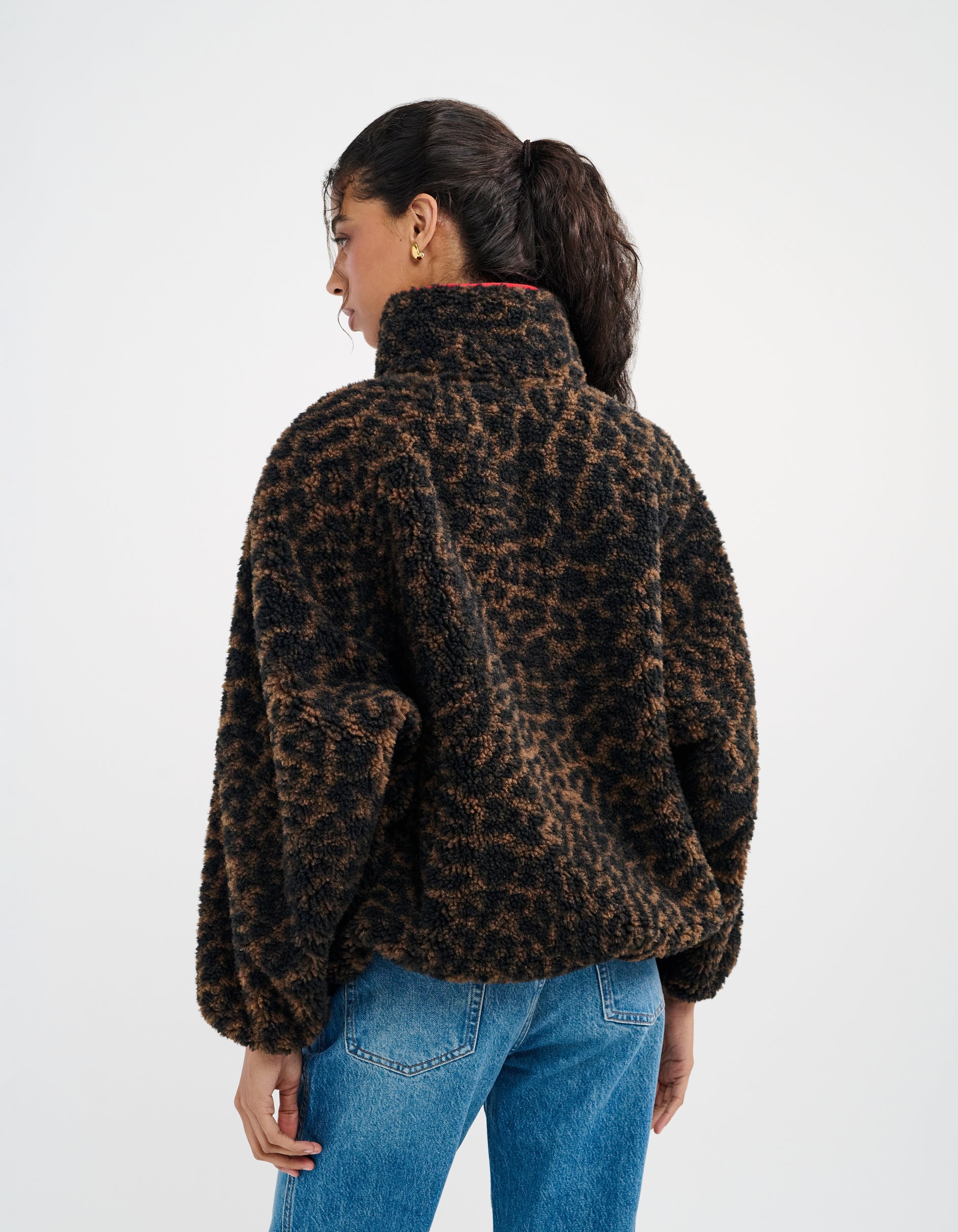 Cheetah Print- featuring a half-zip henley neckline outlined in red, oversized pockets positioned at the waist outlined in red, and raglan sleeves