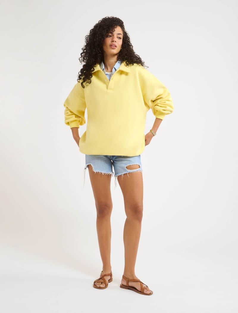 A model poses wearing Rumored 100% Cotton Airport Sweatshirt in Buttercream