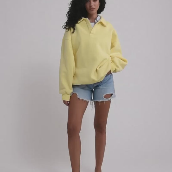 A model poses wearing Rumored 100% Cotton Airport Sweatshirt in Buttercream