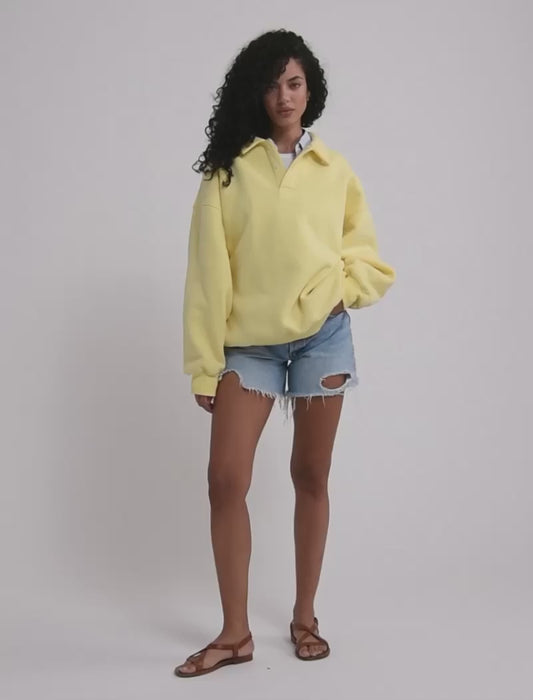 A model poses wearing Rumored 100% Cotton Airport Sweatshirt in Buttercream